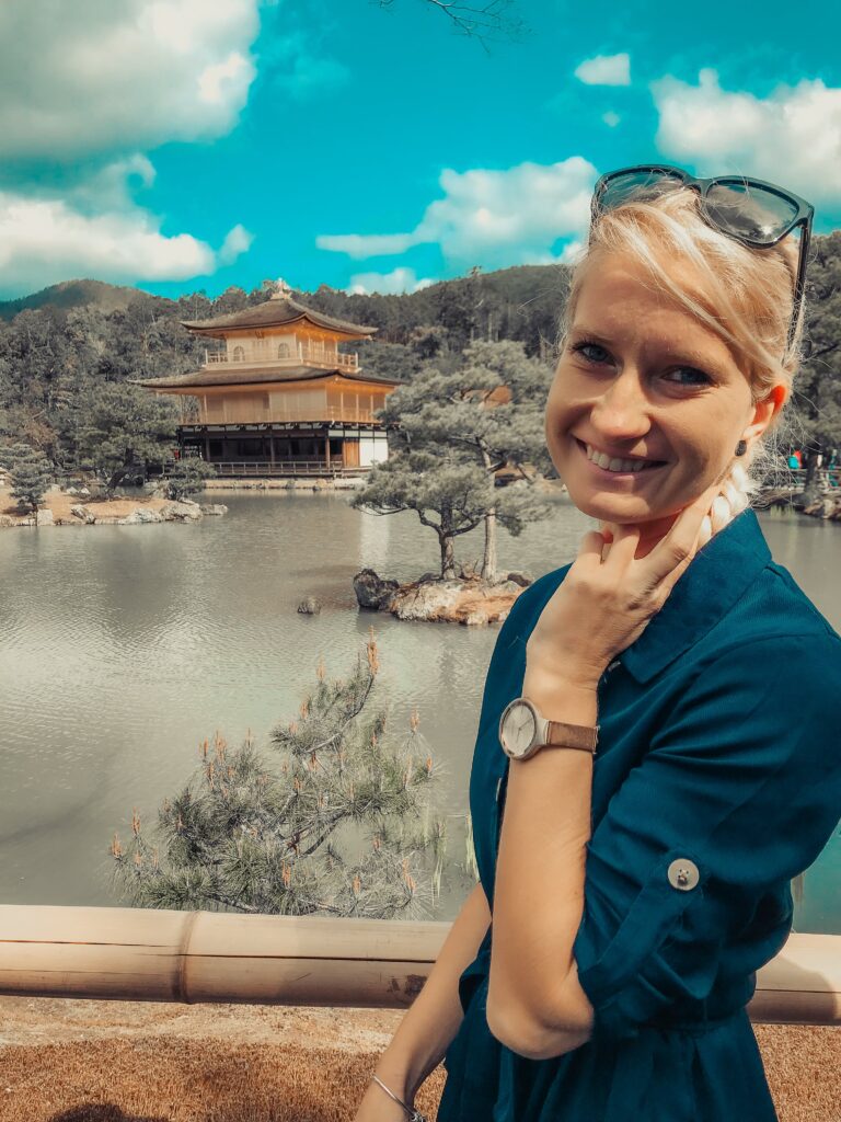 Anja On Adventure in Kyoto, Japan, in Front of Kinkaki-ji Temple, wearing a blue dress. 