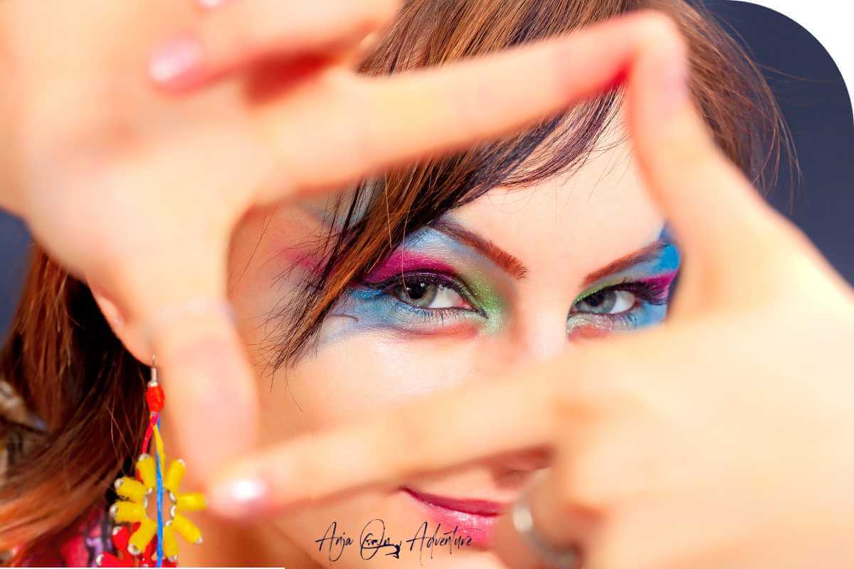 focus on womans eyes wearing eyeshadow in rainbow colors